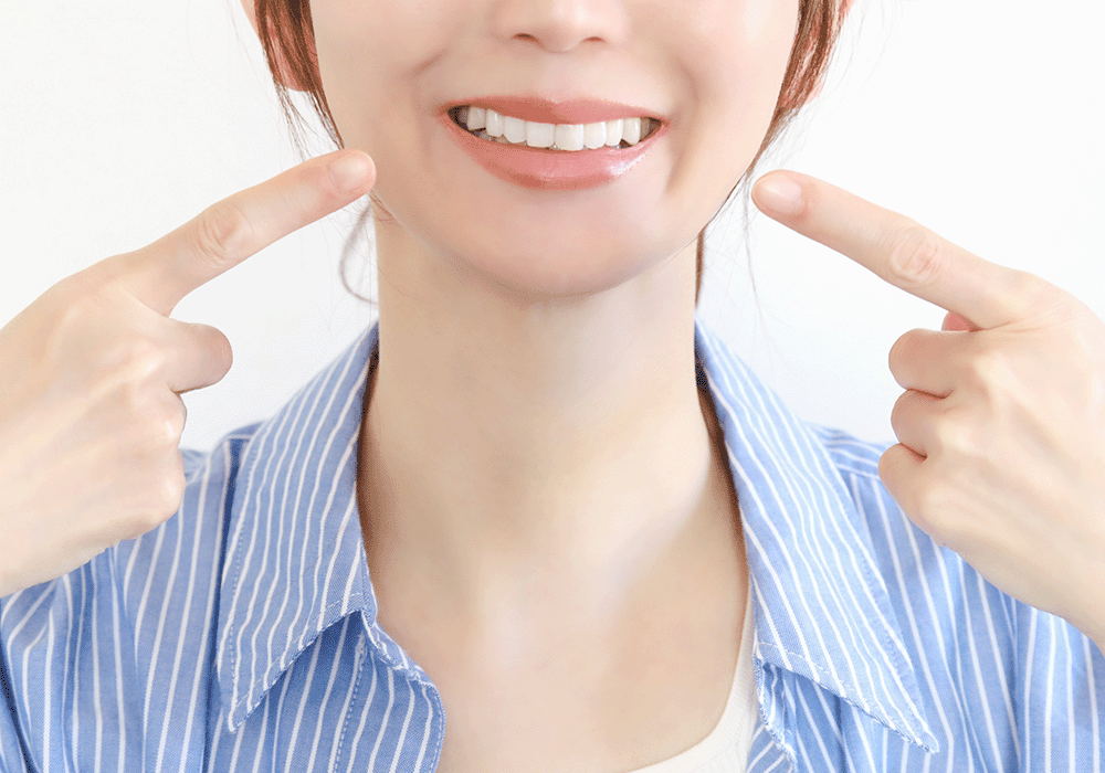 口元を指さす女性